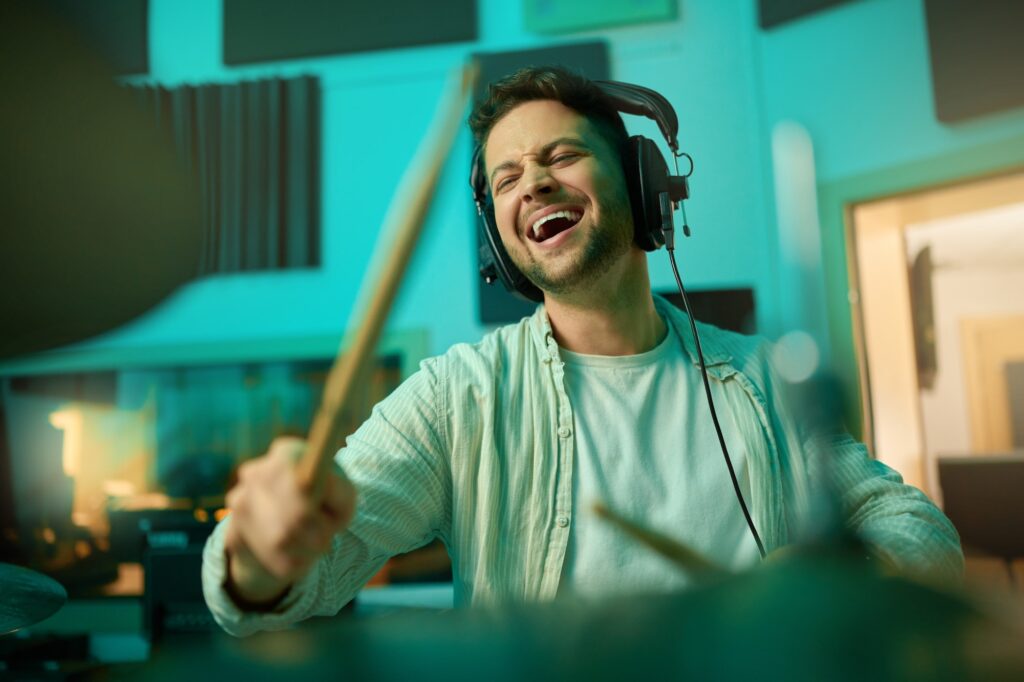 Musician, headphones and man drummer playing in a recording studio for production of a song. Musica
